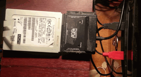 Un disque connecté à un ordinateur par un adaptateur USB/SATA